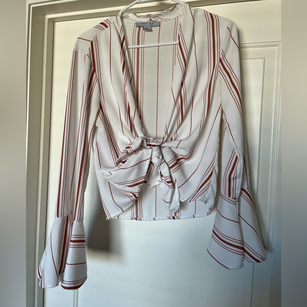 White medium crop top with orange stripes and bell sleeves. Cute and casual.